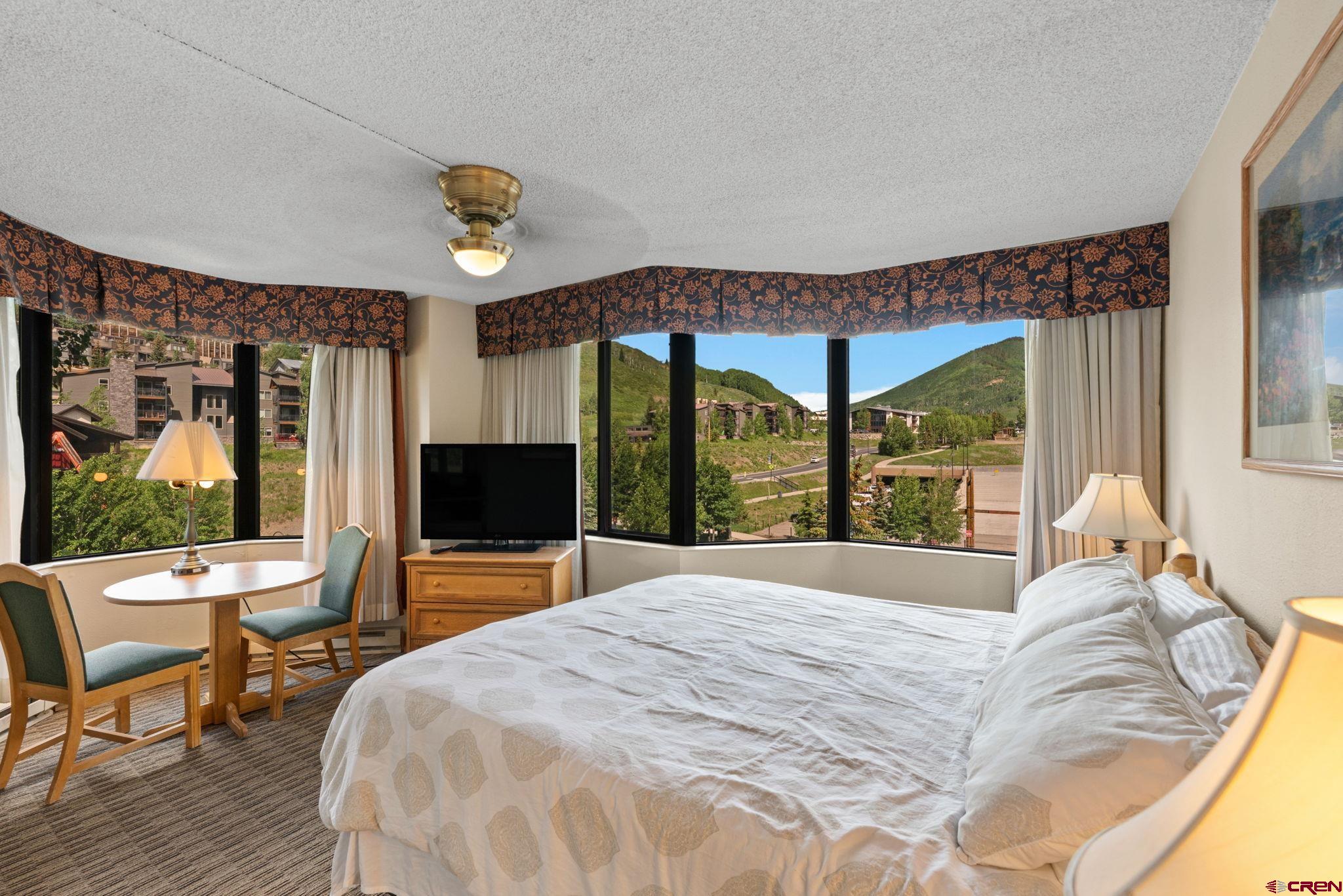 6 Emmons Road, Unit 452 & 454 Crested Butte, CO 81225 - Photo 13 of 38 a bedroom with a bed and large windows