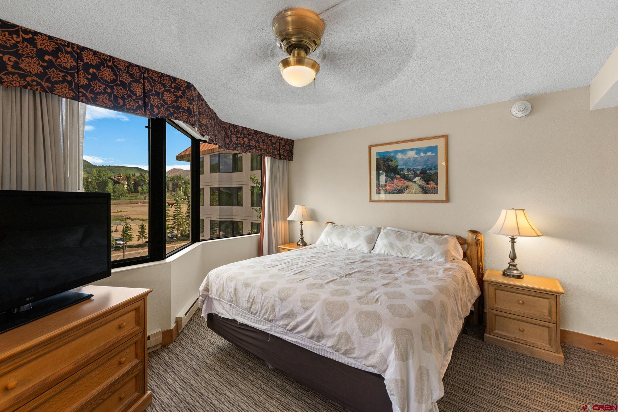 6 Emmons Road, Unit 452 & 454 Crested Butte, CO 81225 - Photo 14 of 38 a bedroom with a bed and a flat tv screen on dresser