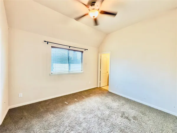 an empty room with a window and a ceiling fan