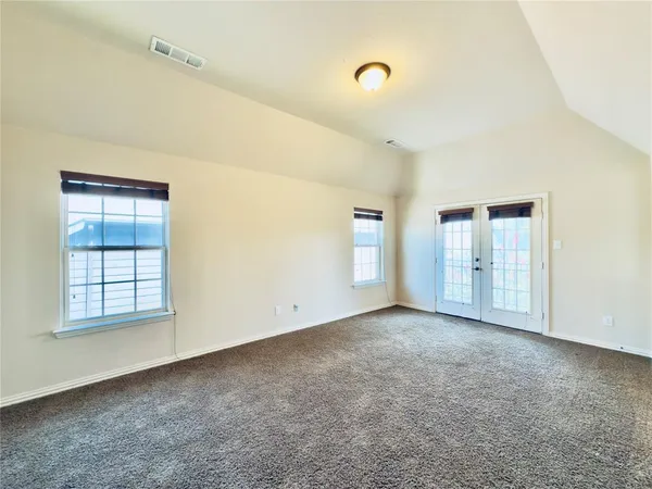 an empty room with a projector and windows