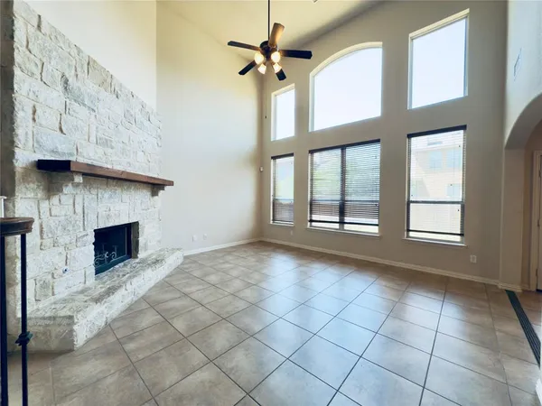 a view of an empty room with a fireplace and a window