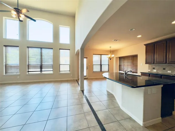 a kitchen with kitchen island granite countertop a stove sink and cabinets