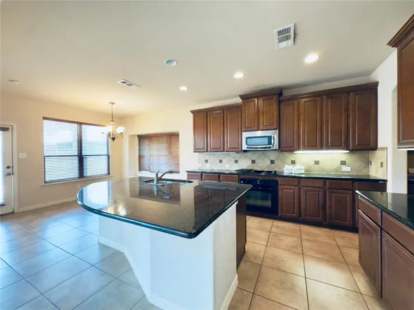 a kitchen with stainless steel appliances granite countertop a sink stove and cabinets