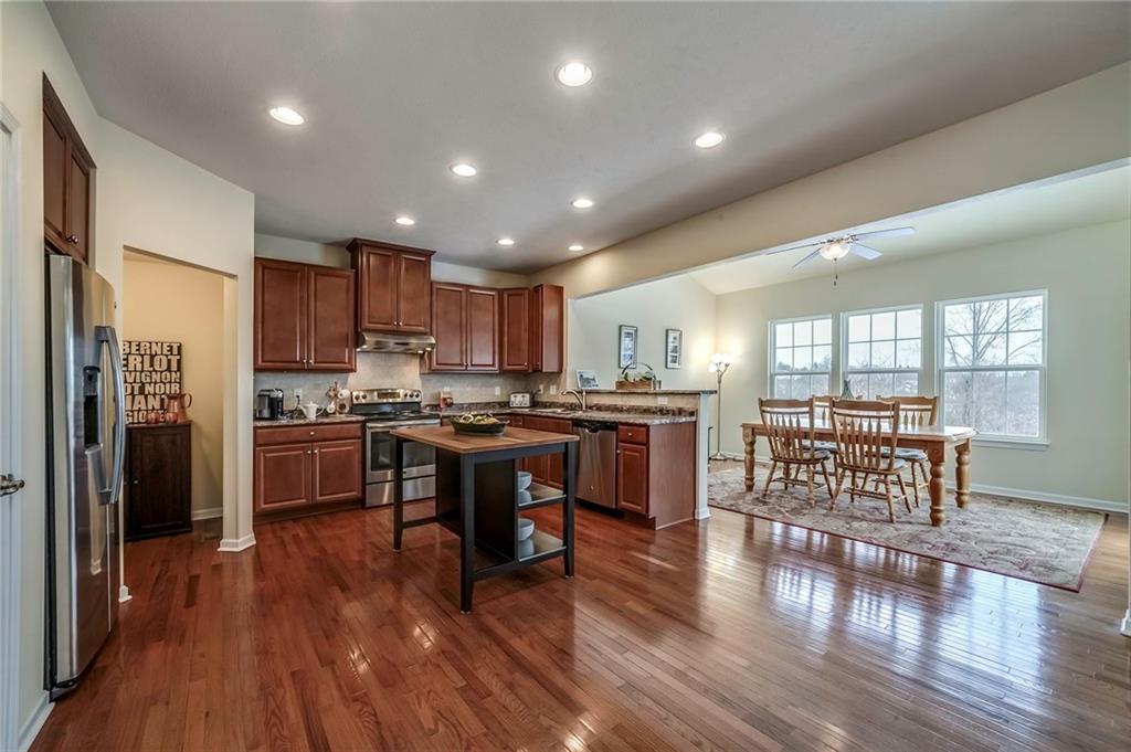 171 Cimarron Drive Moon Township, PA 15108 - Photo 6 of 25 a kitchen with stainless steel appliances kitchen island granite countertop wooden floors a stove and a sink