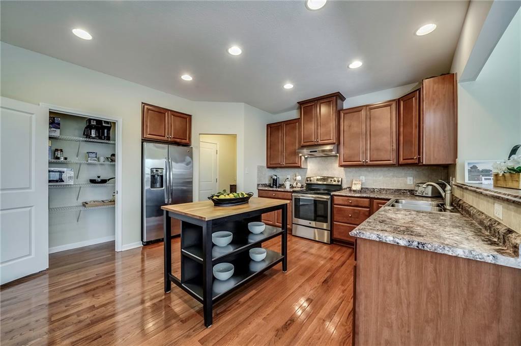 171 Cimarron Drive Moon Township, PA 15108 - Photo 8 of 25 a kitchen with stainless steel appliances granite countertop wooden cabinets a sink dishwasher a stove and a refrigerator with wooden floor