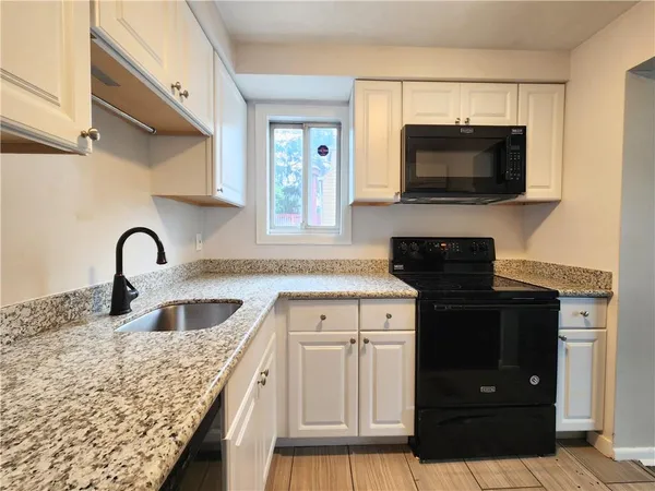 a kitchen with granite countertop a sink and a microwave