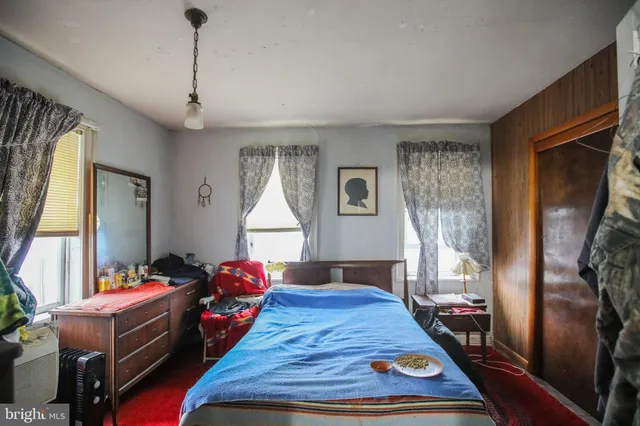 a bed room with a bed window and a flat tv screen