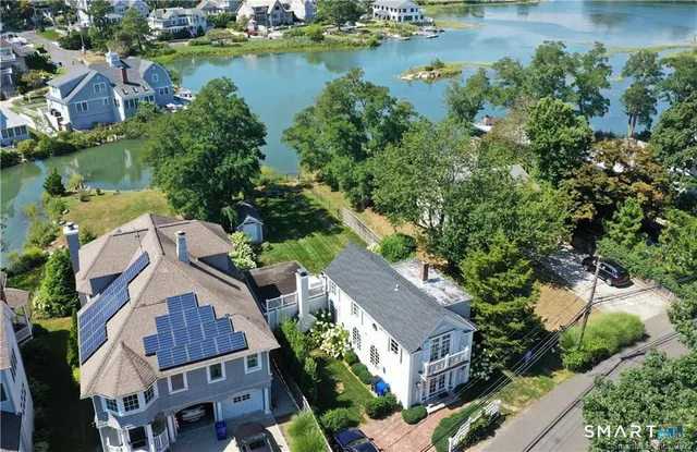 an aerial view of residential houses with outdoor space and lake view