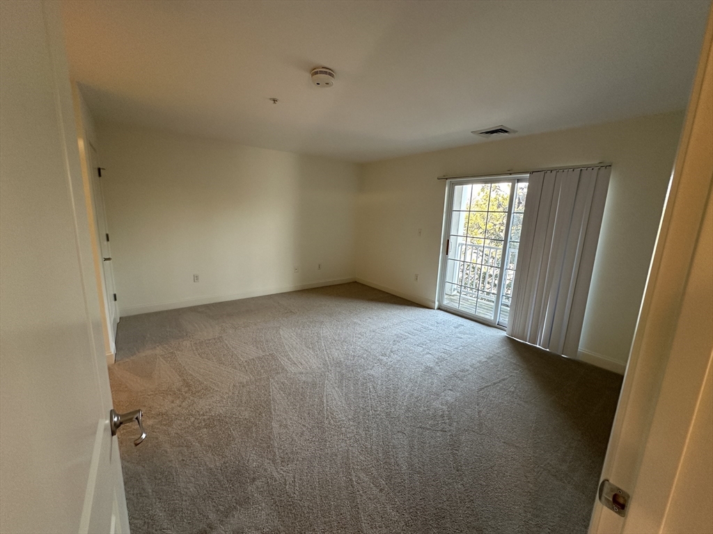 318 Rindge Avenue, Unit 216 Cambridge, MA 02140 - Photo 7 of 15 an empty room with windows