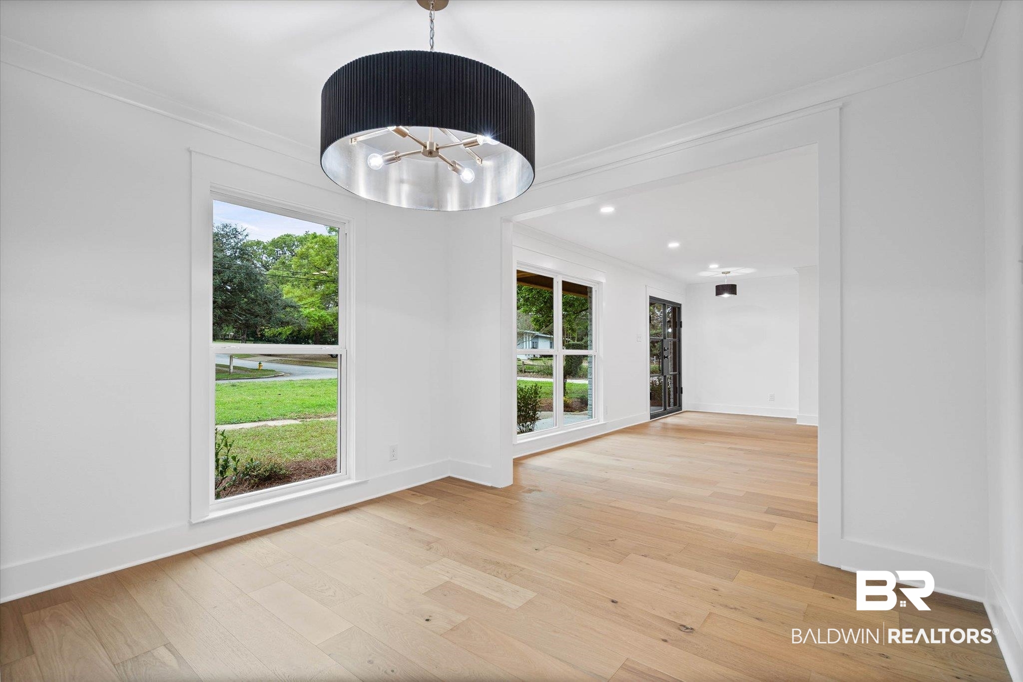 11 Schwaemmle Drive Mobile, AL 36608 - Photo 10 of 32 Unfurnished dining area with light wood finished floors, healthy amount of natural light, a chandelier, and ornamental molding