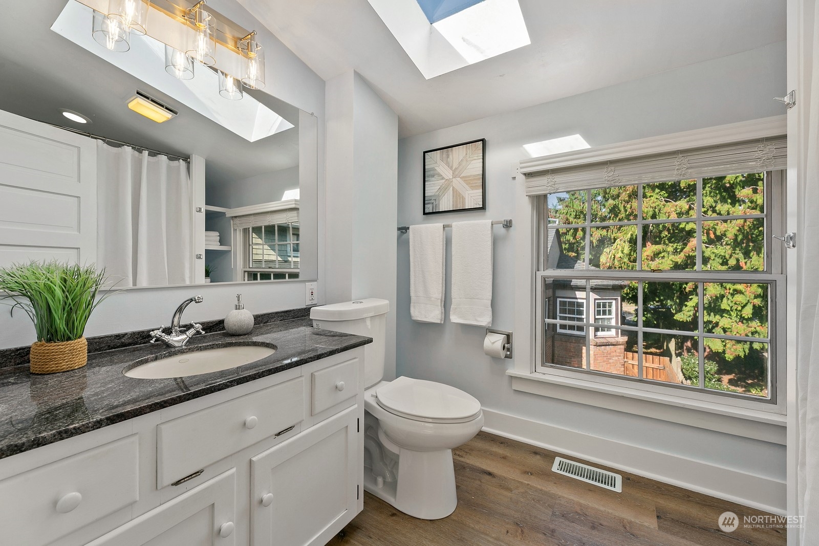 8053 12th Avenue Northeast Seattle, WA 98115 - Photo 26 of 27 a bathroom with a granite countertop sink toilet and mirror