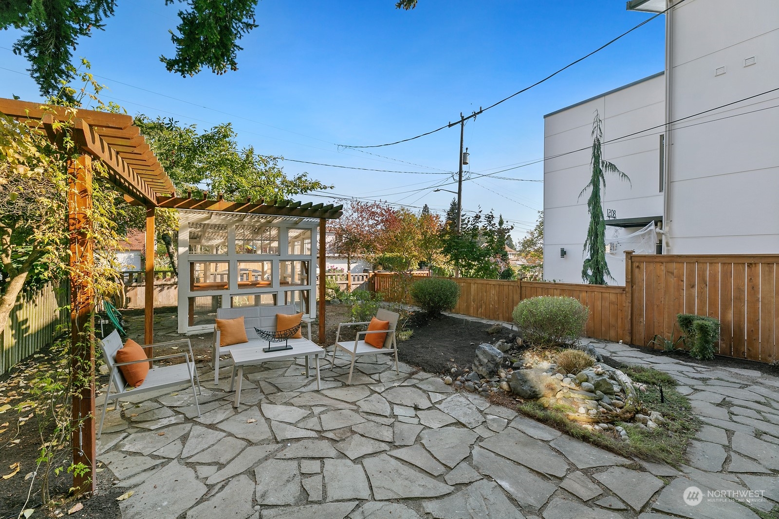 8053 12th Avenue Northeast Seattle, WA 98115 - Photo 3 of 27 a view of a patio with table and chairs potted plants and large tree