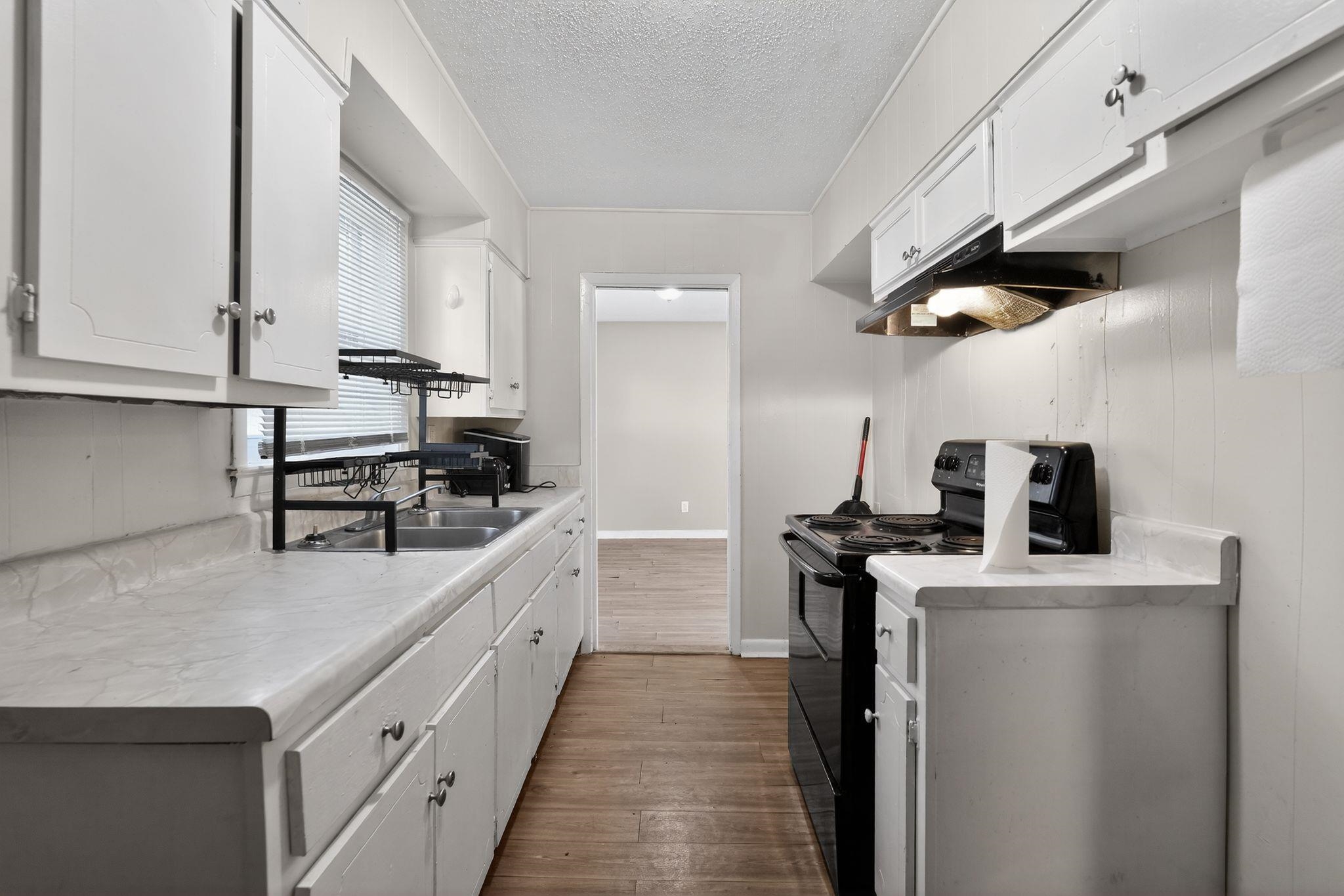 2144 St Elmo Avenue Memphis, TN 38127 - Photo 12 of 31 a kitchen with kitchen island a counter top space a sink stainless steel appliances and cabinets