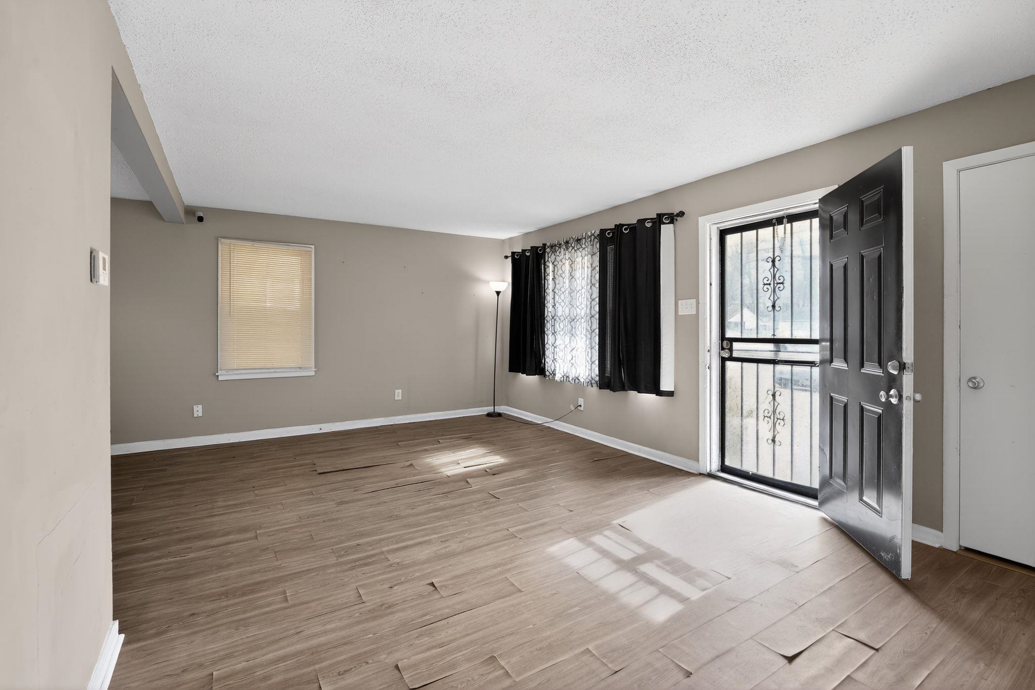 2144 St Elmo Avenue Memphis, TN 38127 - Photo 4 of 31 a view of an empty room with wooden floor and a window