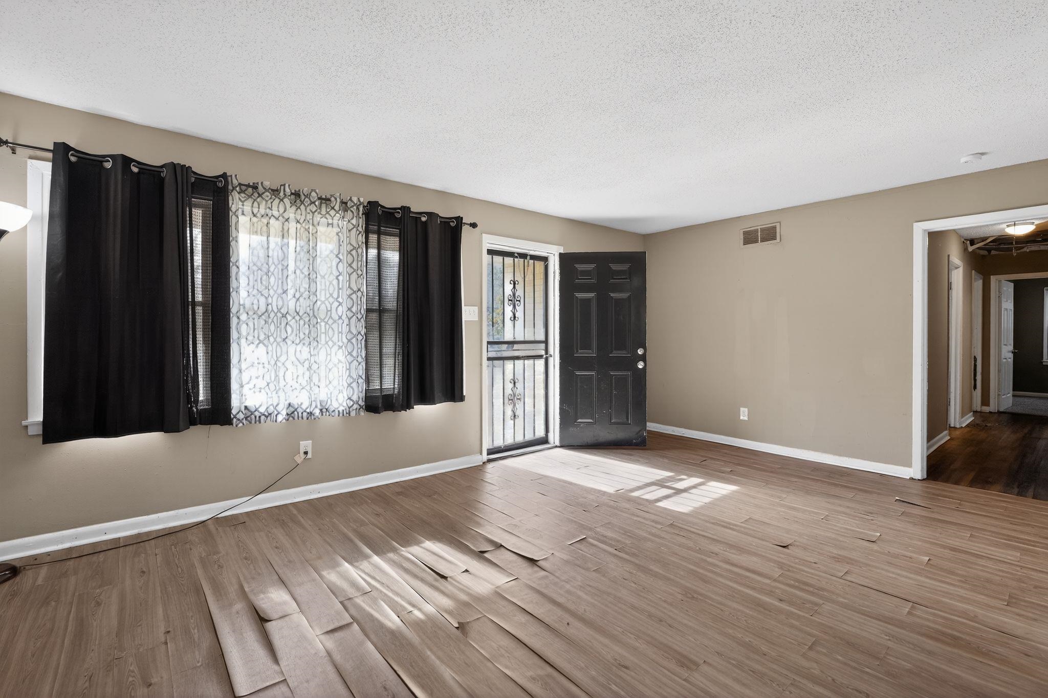 2144 St Elmo Avenue Memphis, TN 38127 - Photo 6 of 31 a view of an empty room with wooden floor and a window