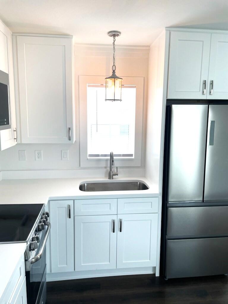 45 Rosin Cup Circle Santa Rosa Beach, FL 32459 - Photo 5 of 10 a kitchen with a sink a refrigerator a window and cabinets