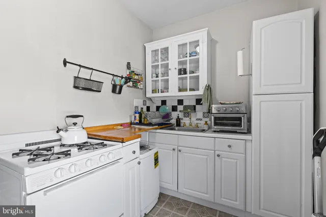 a kitchen with white cabinets and white appliances