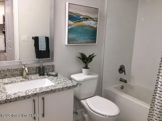 a bathroom with a granite countertop sink a toilet and bathtub