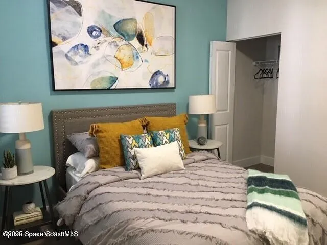 a bedroom with a bed and painting on the wall