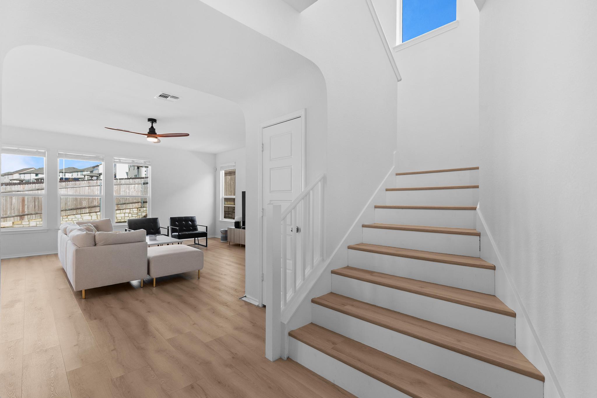 4712 Pear Light Rd Manor Manor, TX 78653 - Photo 15 of 39 Staircase with healthy amount of natural light, a ceiling fan, and wood finished floors