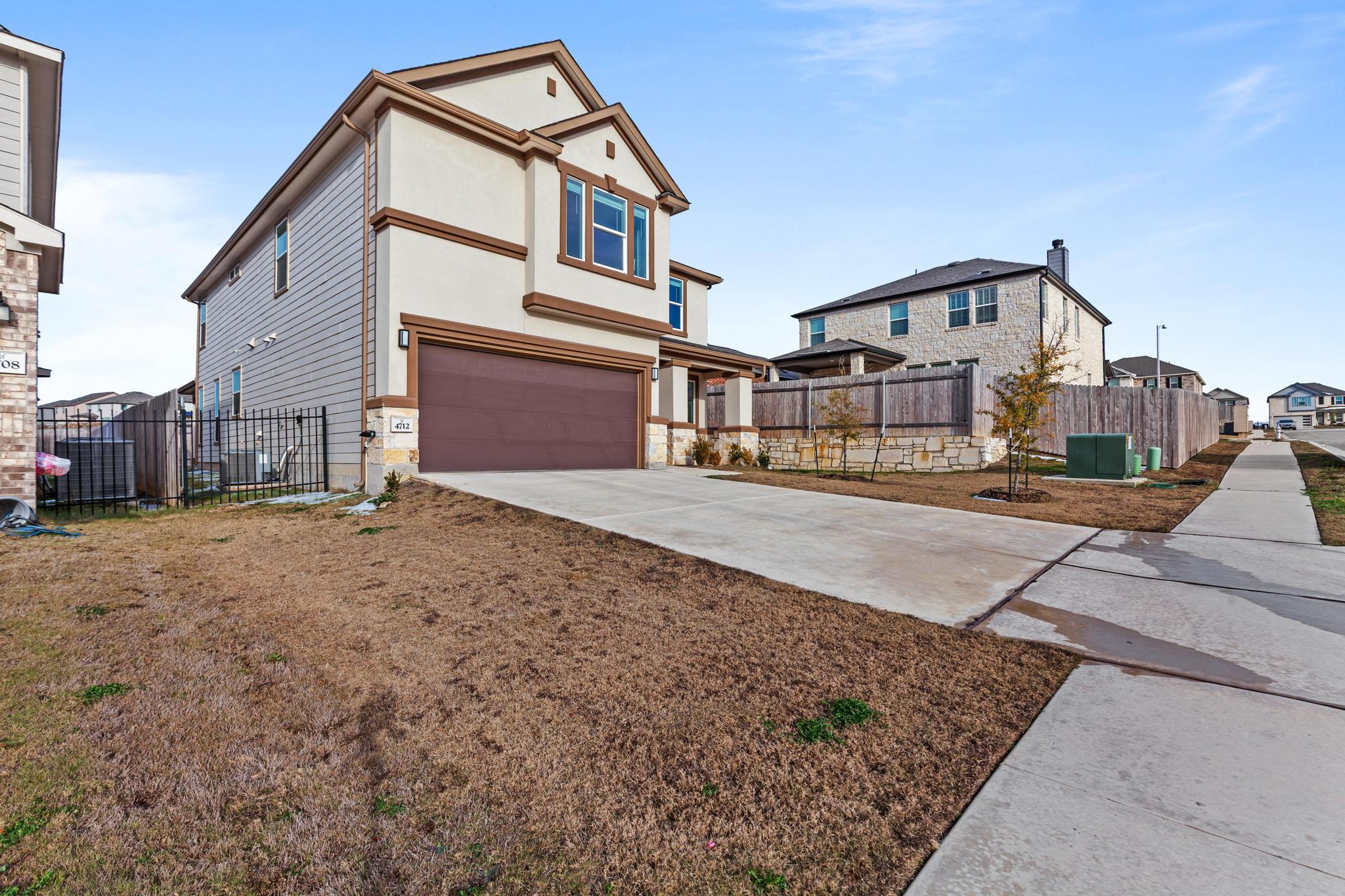 4712 Pear Light Rd Manor Manor, TX 78653 - Photo 3 of 39 View of front of home with driveway, an attached garage, stucco siding, and a residential view