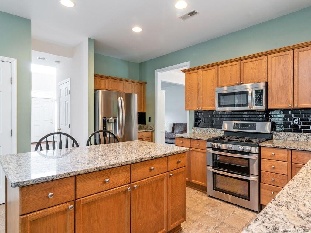 253 Hyde Park Lane Fort Mill, SC 29708 - Photo 11 of 26 a kitchen with stainless steel appliances granite countertop a stove a sink and a microwave