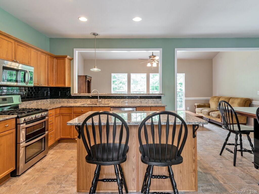 253 Hyde Park Lane Fort Mill, SC 29708 - Photo 8 of 26 a kitchen with stainless steel appliances granite countertop a kitchen island a stove a table and chairs