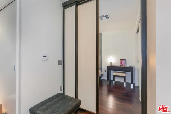 a view of a hallway with wooden floor and furniture