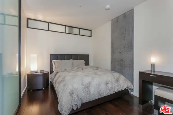 a bedroom with a bed and a night stand