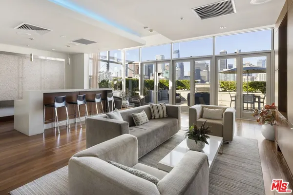 a living room with furniture wooden floor and a large window