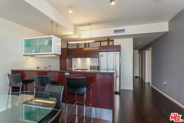 a room with stainless steel appliances kitchen island granite countertop furniture and a large window