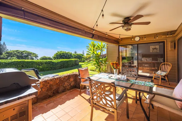 a view of a patio with a table chairs and a floor to ceiling window