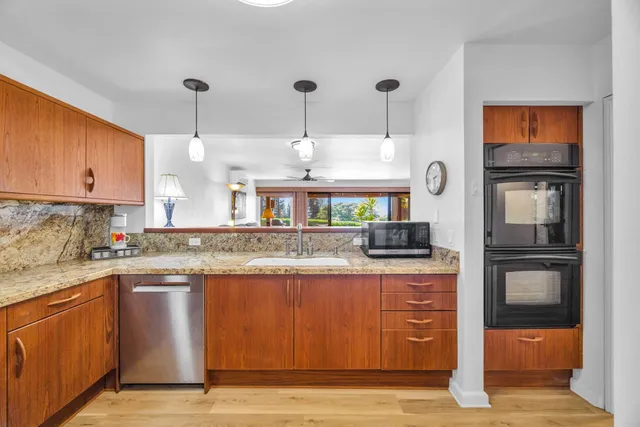 a kitchen with stainless steel appliances granite countertop a sink a stove and a refrigerator