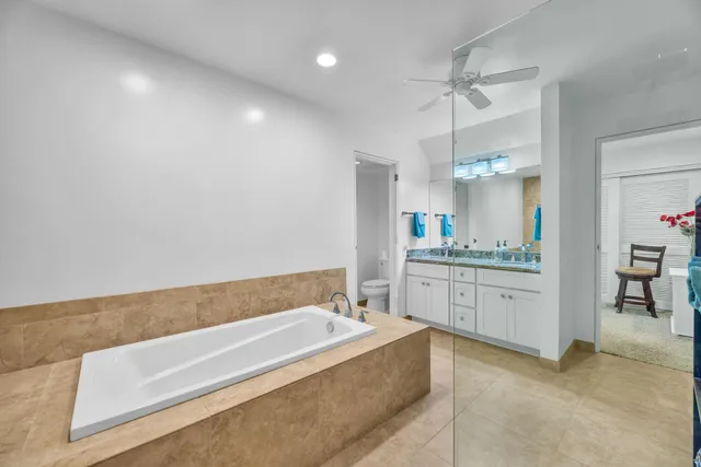 a spacious bathroom with a granite countertop sink mirror and bathtub