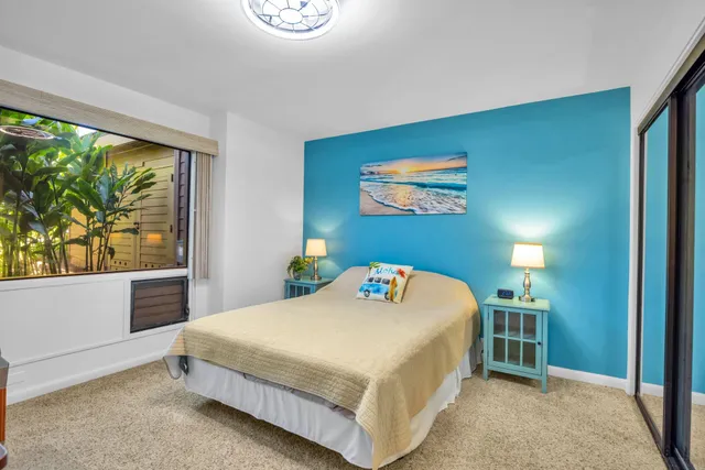 a bedroom with a bed and a large window