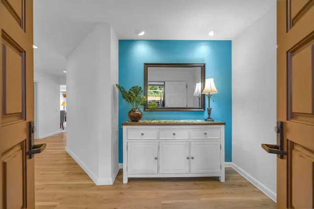 a view of a hallway to front door with wooden floor