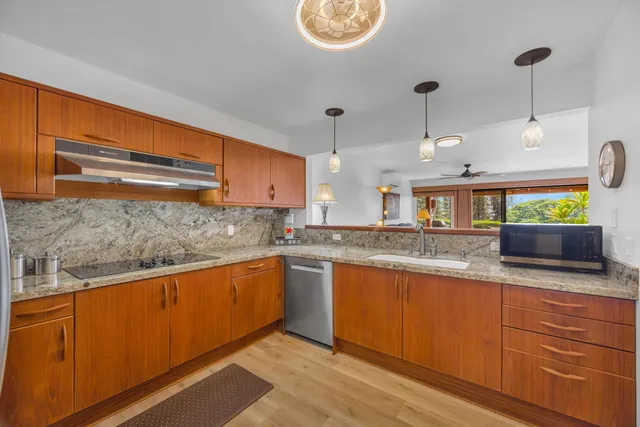 a kitchen with granite countertop a sink and cabinets