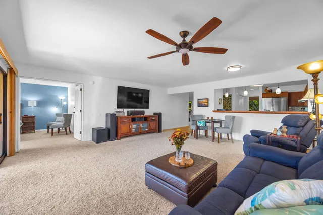 a living room with furniture and a view of kitchen