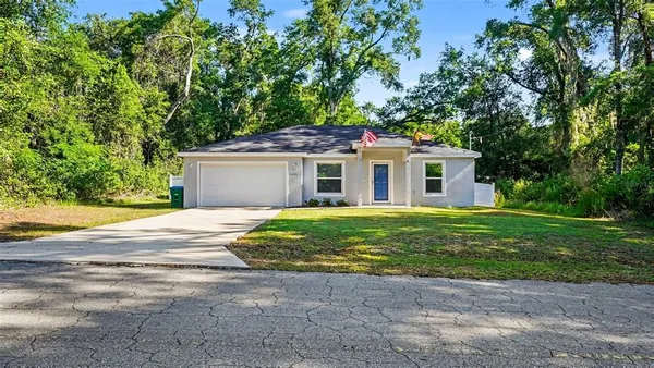 a front view of house with a garden