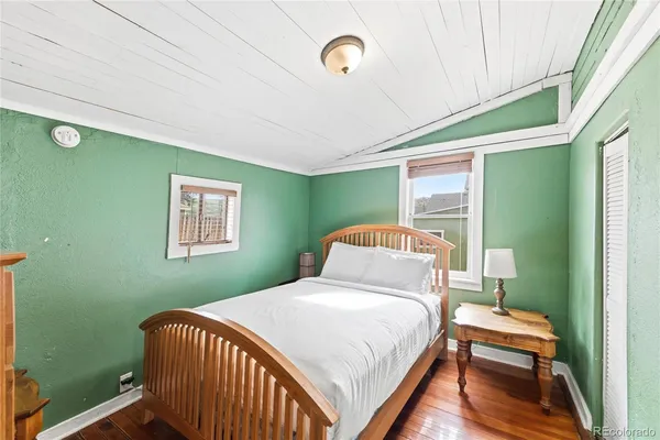 a bedroom with a bed and wooden floor