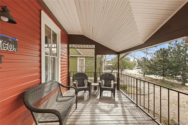 a porch area with table and chairs