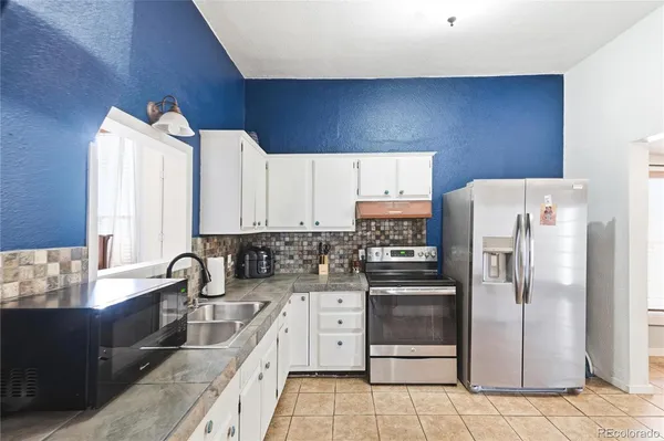 a kitchen with stainless steel appliances a refrigerator sink and cabinets