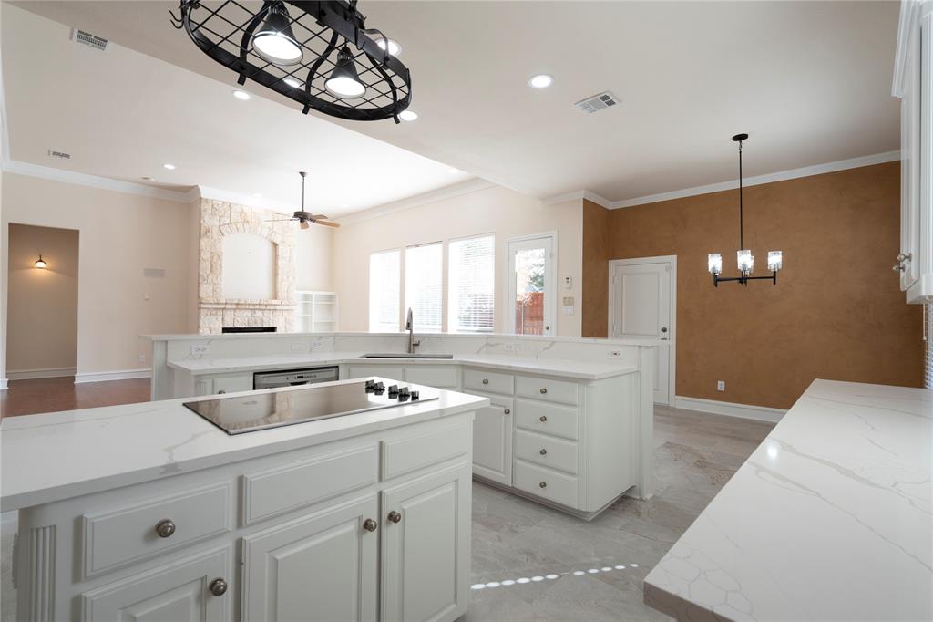 1425 Kingsmill Court Coppell, TX 75019 - Photo 20 of 30 a kitchen with white cabinets appliances and a chandelier