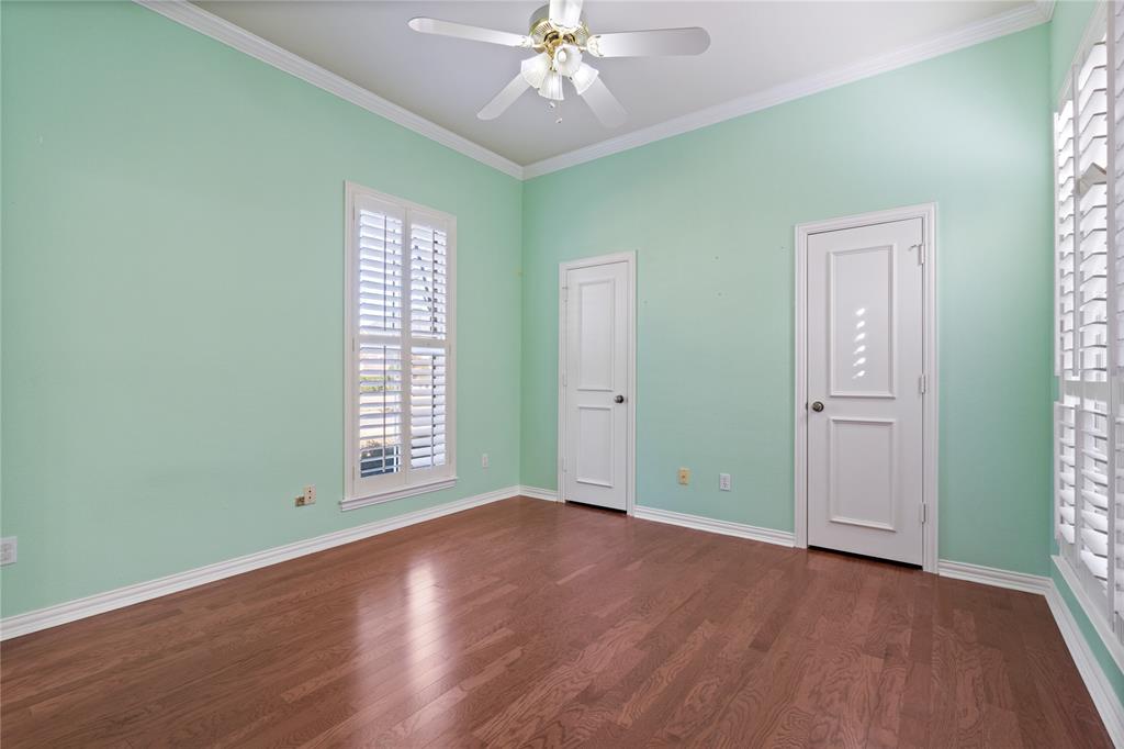 1425 Kingsmill Court Coppell, TX 75019 - Photo 28 of 30 an empty room with wooden floor chandelier fan and windows