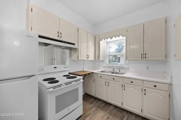 a kitchen with granite countertop white cabinets and white appliances