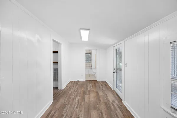 a view of a room with wooden floor and white walls