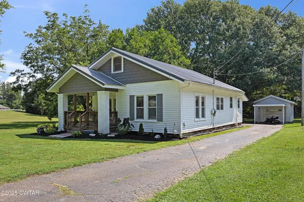 a front view of a house with a yard deck and trees