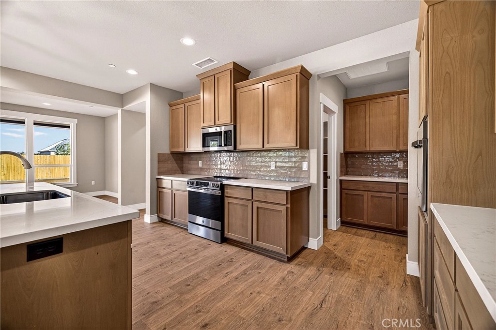2749 Waterloo Circle Chico, CA 95973 - Photo 15 of 71 a kitchen with stainless steel appliances kitchen island granite countertop a stove a sink and a refrigerator