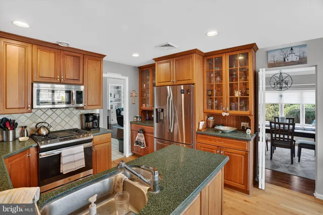 a kitchen with stainless steel appliances granite countertop a refrigerator stove microwave and sink