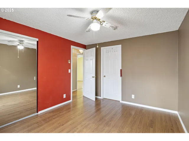 a view of an empty room with window and a ceiling fan